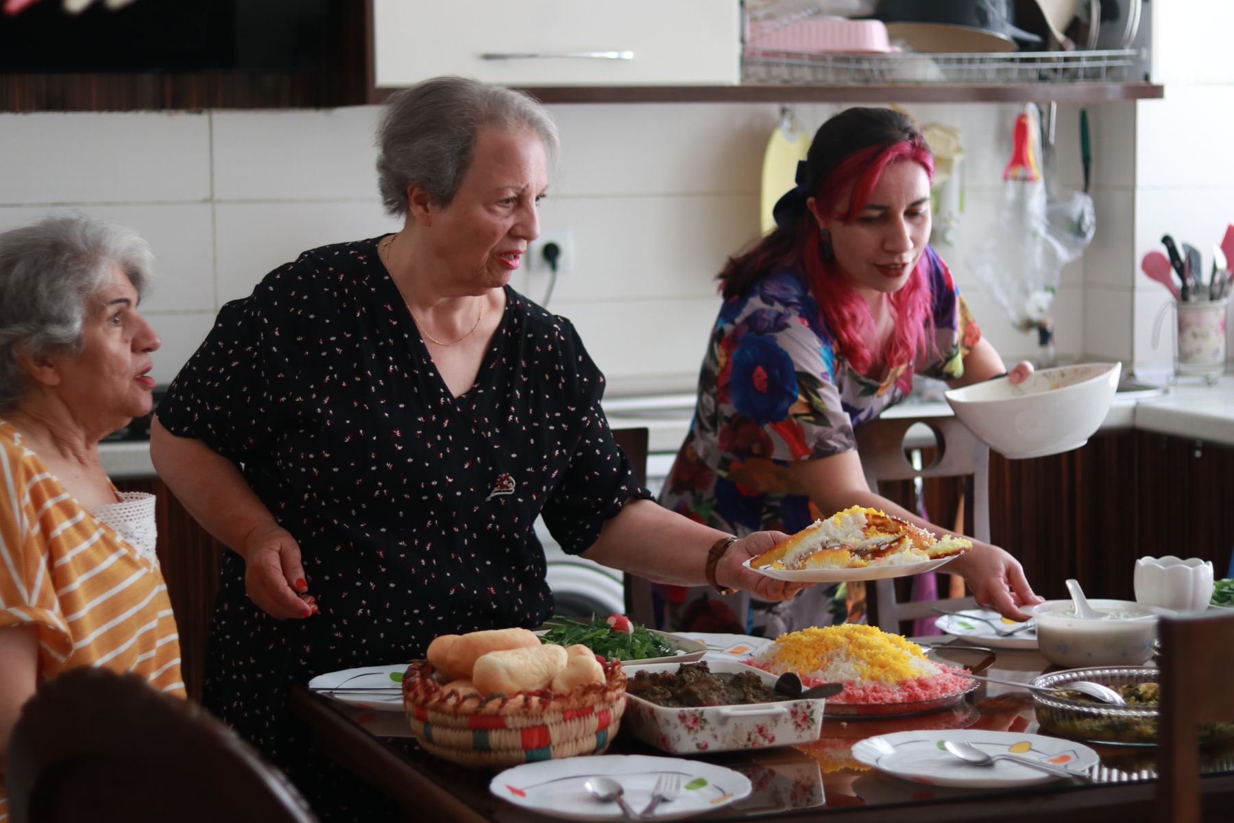 Residents and staff putting a shared meal on the table
