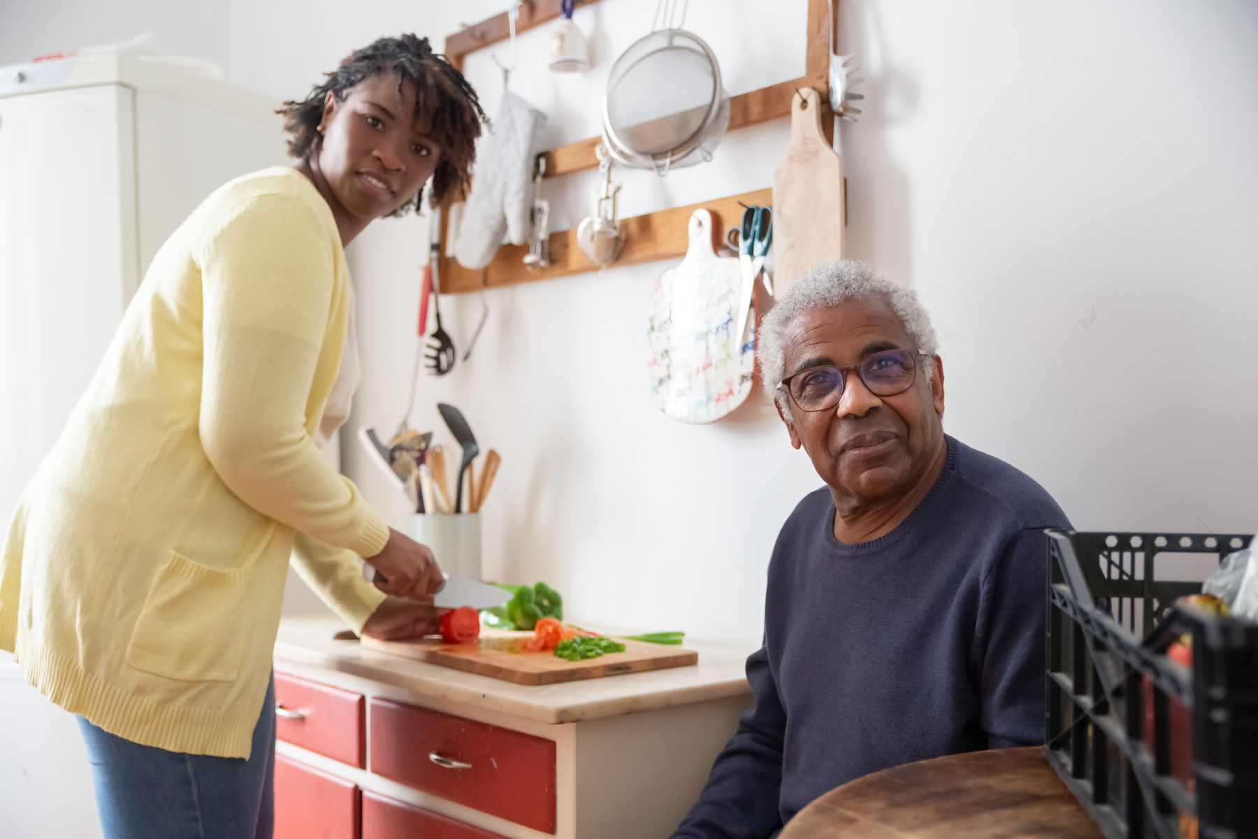 A caregiver making lunch while a resident sits with her at the kitchen counter